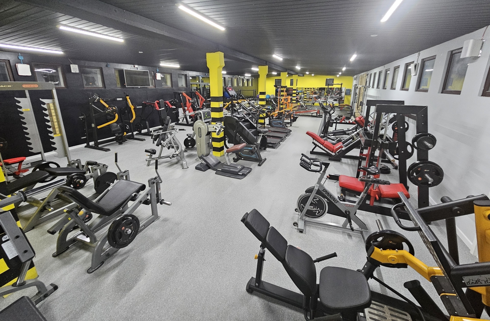 Jasna, przestronna sala treningowa FRICK GYM z żółtymi filarami